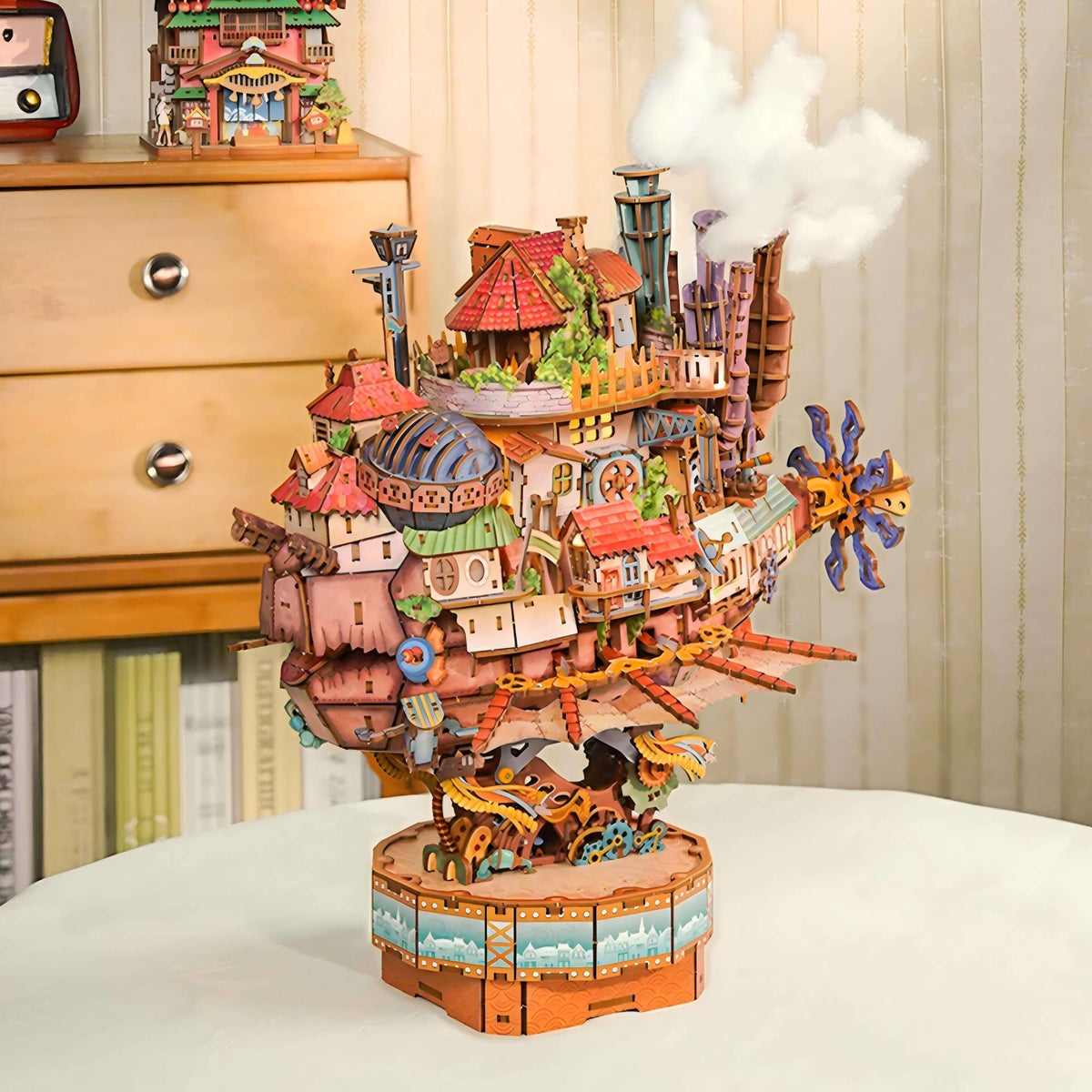 Colorful toy ship model on a white surface with a wooden dresser in the background