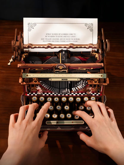 A vintage-style wooden typewriter with ornate metal details and a printed poem on the page, being used by two hands typing on a dark wood desk.